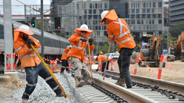 Three track workers repairing the rail line